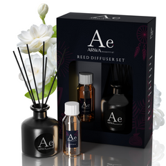 ARWA Essential Jasmine Reed Diffuser Set - black ceramic diffuser pot with reed sticks, fragrance oil bottle and refill bottle with packaging box, white jasmine flowers in background