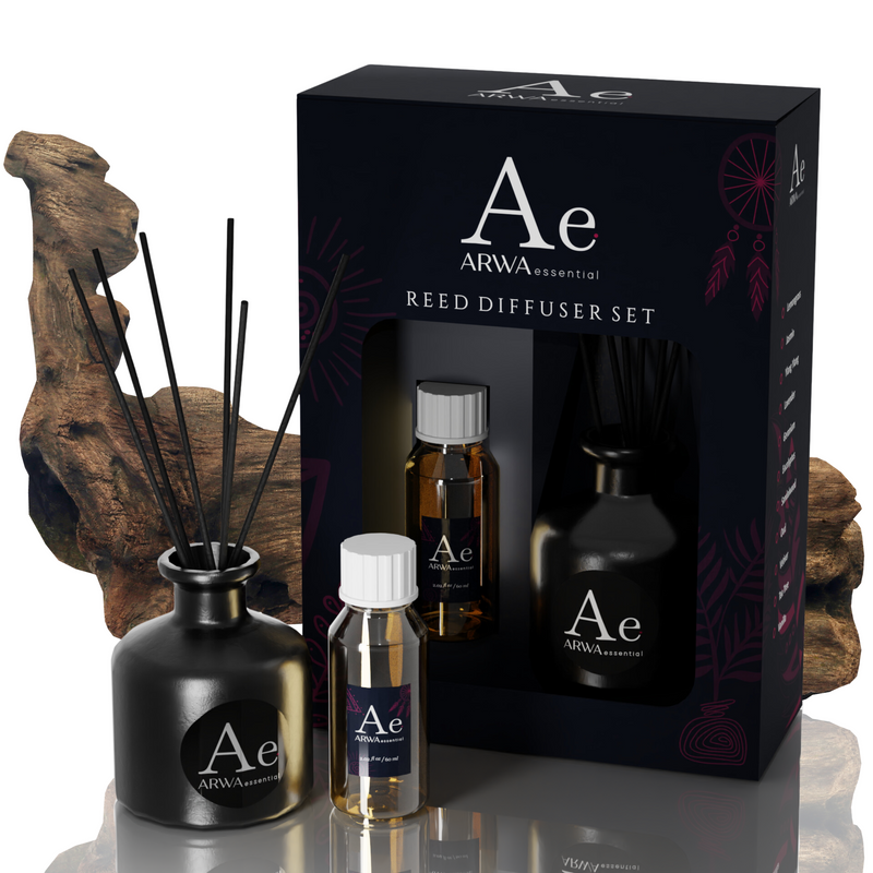 ARWA Essential Oud Reed Diffuser Set - black ceramic diffuser pot with reed sticks, fragrance oil bottle and refill bottle with packaging box, natural agarwood driftwood in background